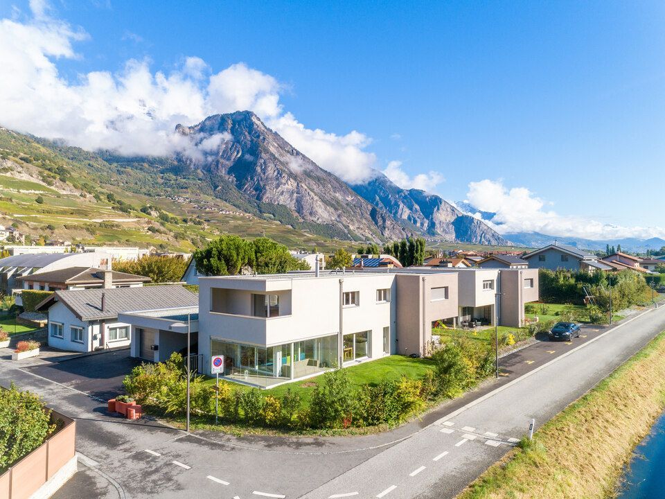 Une vue aérienne d'une maison avec une montagne en arrière-plan.