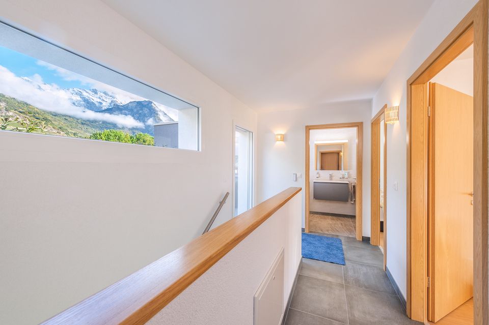 Un couloir avec une fenêtre et une vue sur les montagnes.