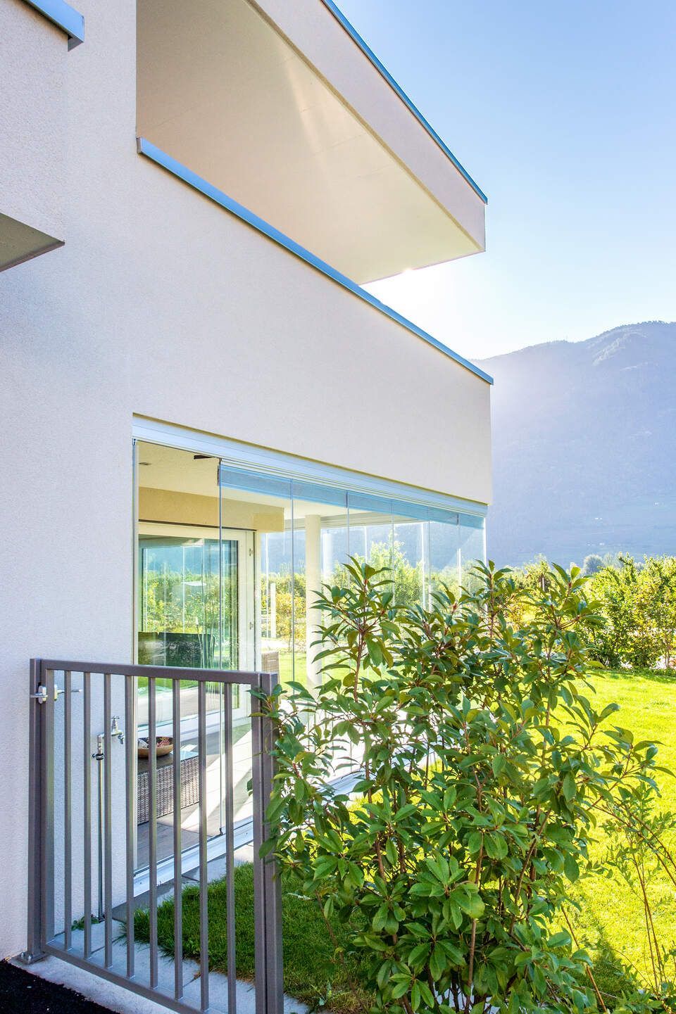 Un bâtiment blanc avec un balcon et des montagnes en arrière-plan