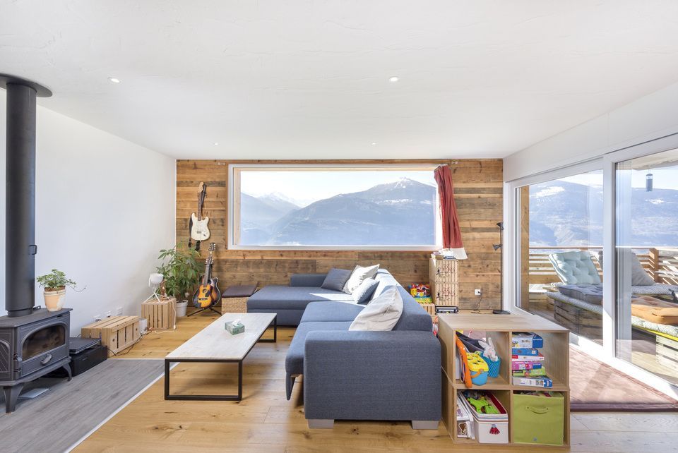 Un salon avec un canapé, une table basse et une grande fenêtre.