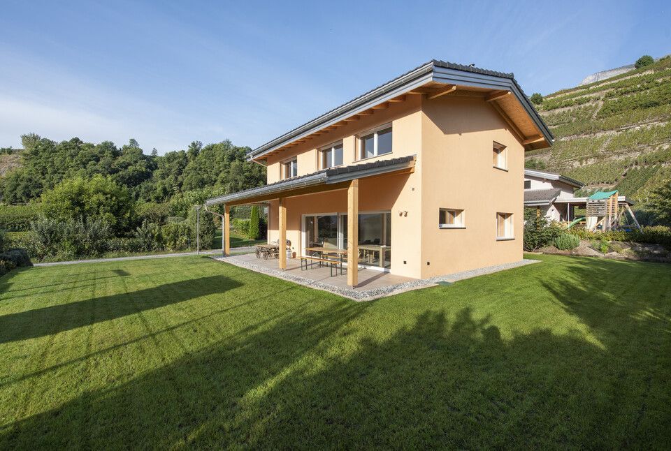 Une maison avec une grande pelouse devant elle
