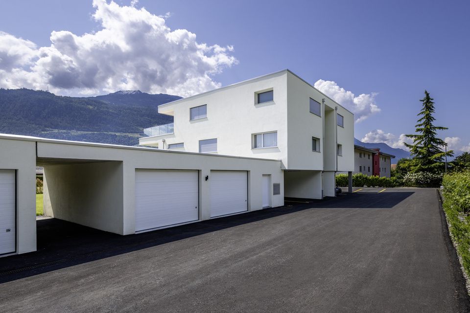 Un bâtiment blanc avec beaucoup de garages devant.