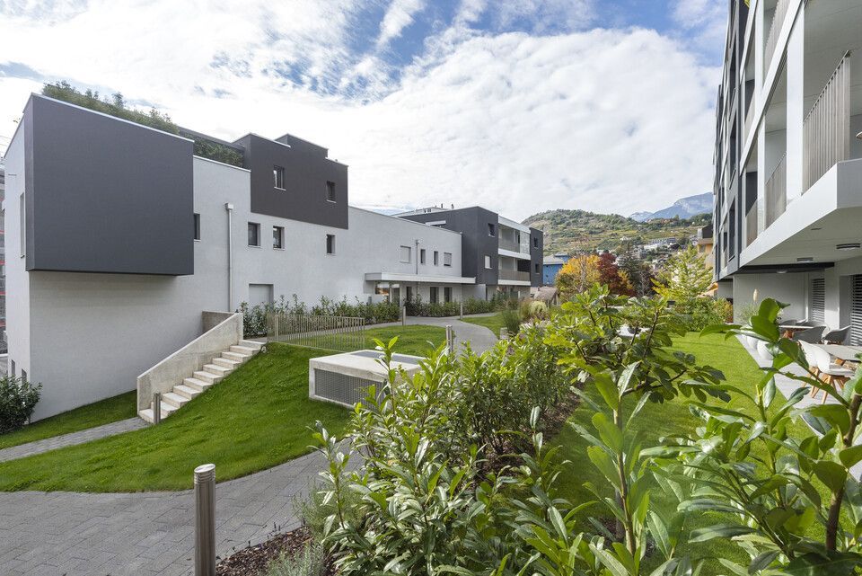 Une rangée de bâtiments avec une pelouse verte luxuriante devant eux.