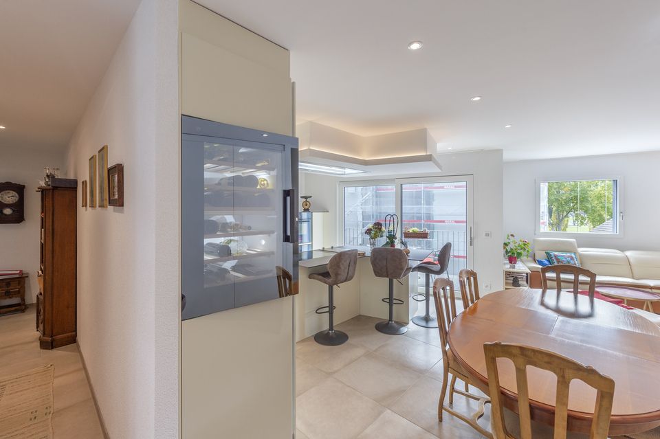 Un salon avec une table et des chaises et une horloge au mur.