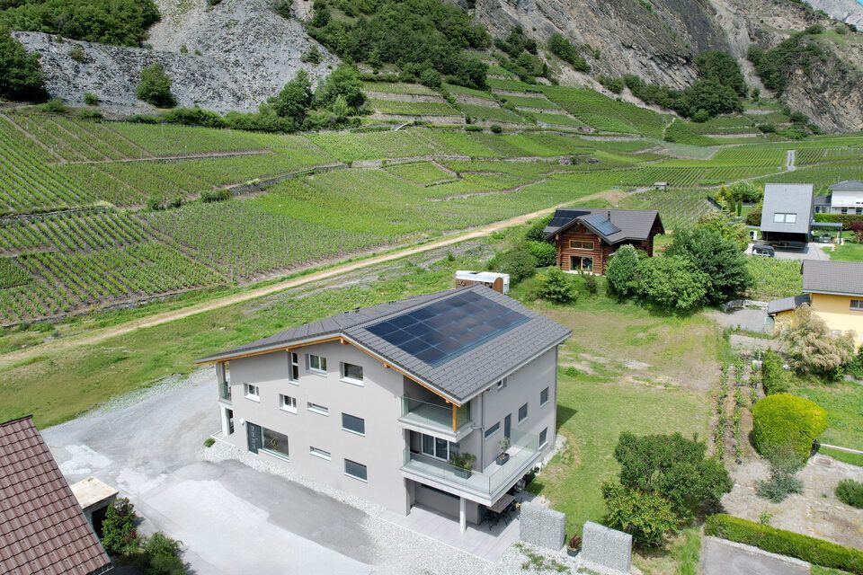 Une vue aérienne d'une maison avec des panneaux solaires sur le toit.