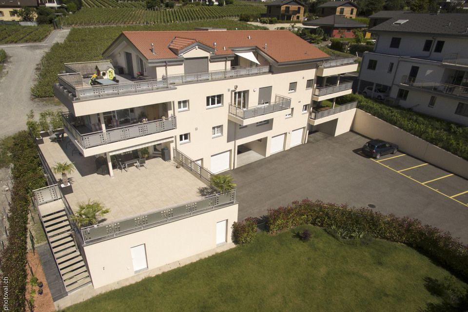 Une vue aérienne d'un grand immeuble d'appartements avec un toit rouge