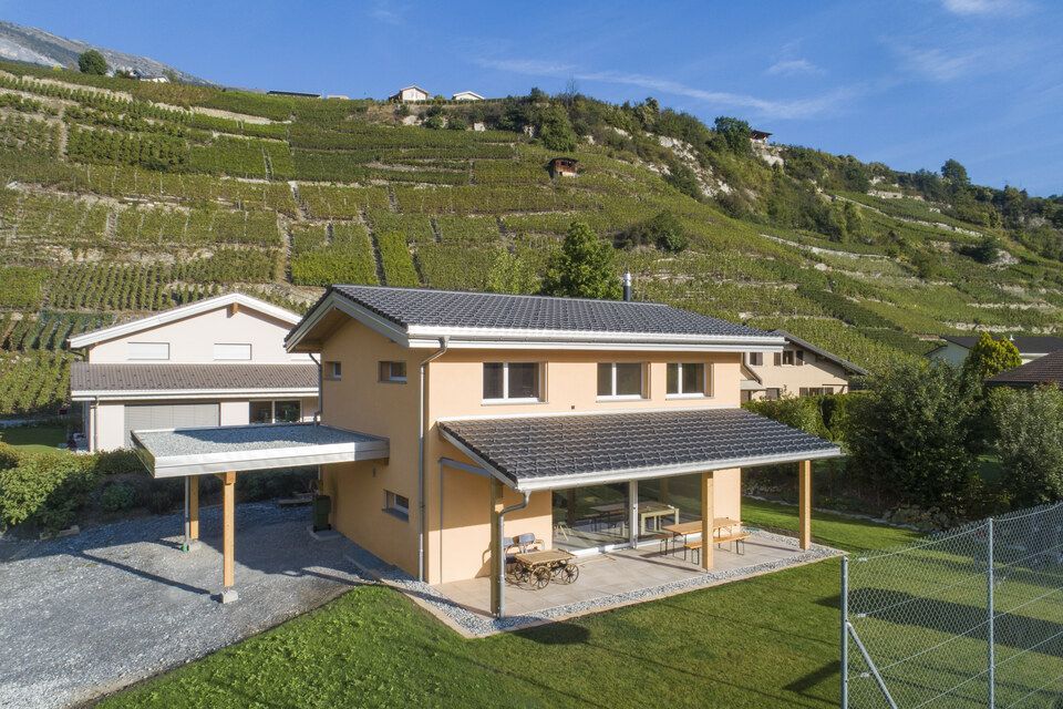 Une vue aérienne d'une maison avec un court de tennis devant.