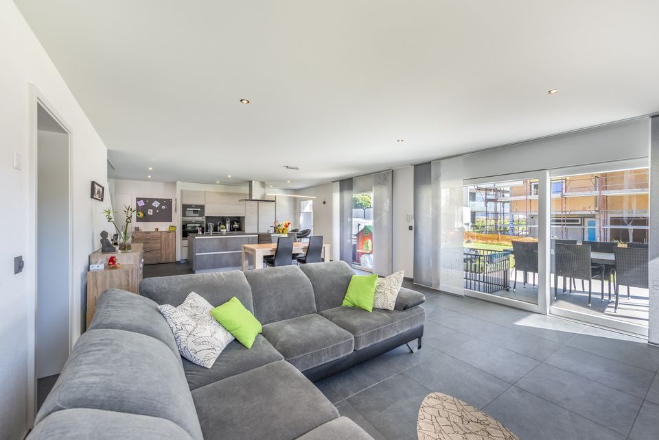 Un salon avec un canapé et une salle à manger en arrière plan.