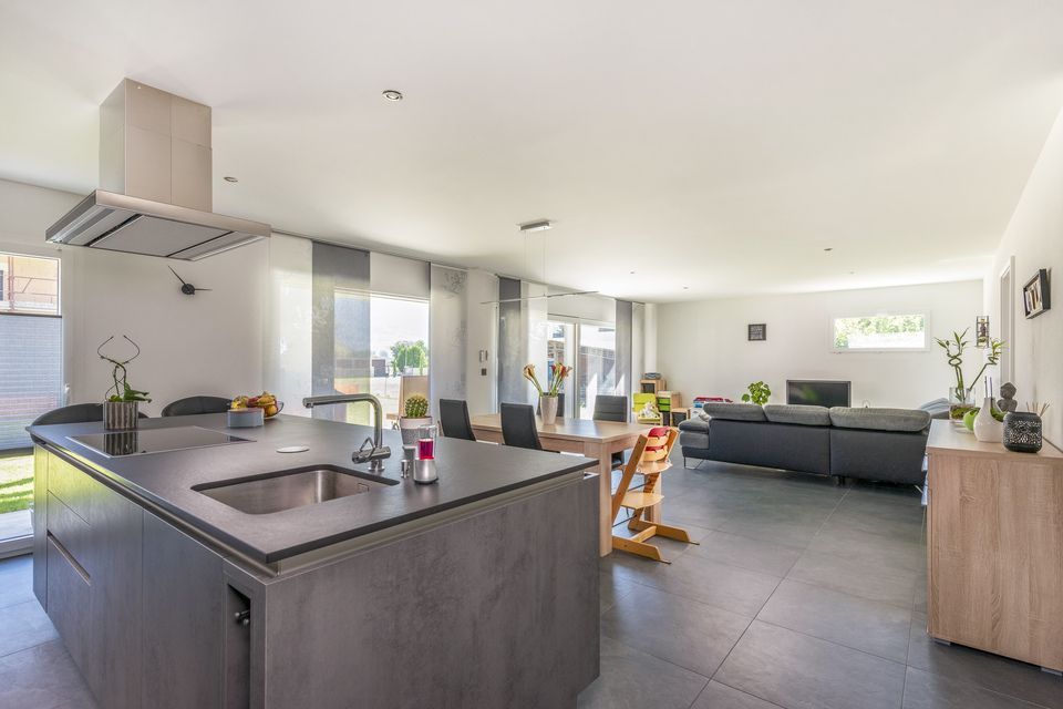 Une cuisine avec un évier, une table à manger et un salon.