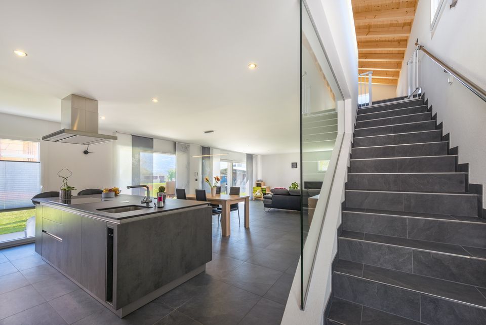 Une cuisine avec un grand îlot et des escaliers qui y mènent.