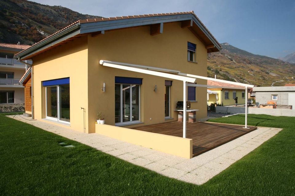 Une maison jaune avec un auvent blanc sur le côté