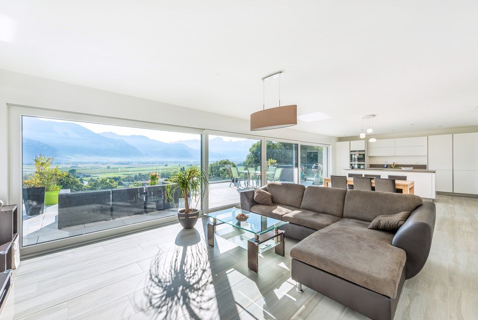 Un salon avec un grand canapé sectionnel et une table basse en verre.