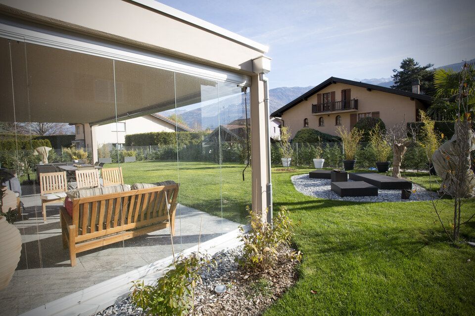 Un patio avec un canapé et des chaises devant une maison