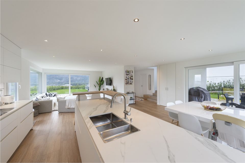 Une cuisine avec un évier et une table à manger dans une maison.