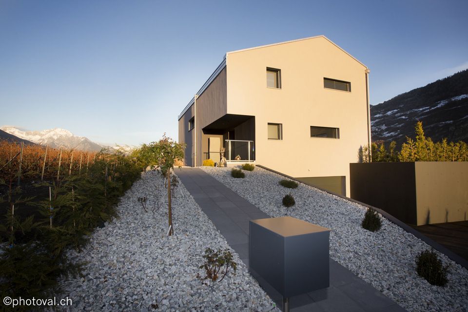 Une maison est assise au sommet d'une colline entourée de gravier.