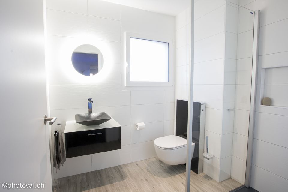 Une salle de bain avec WC, lavabo et miroir
