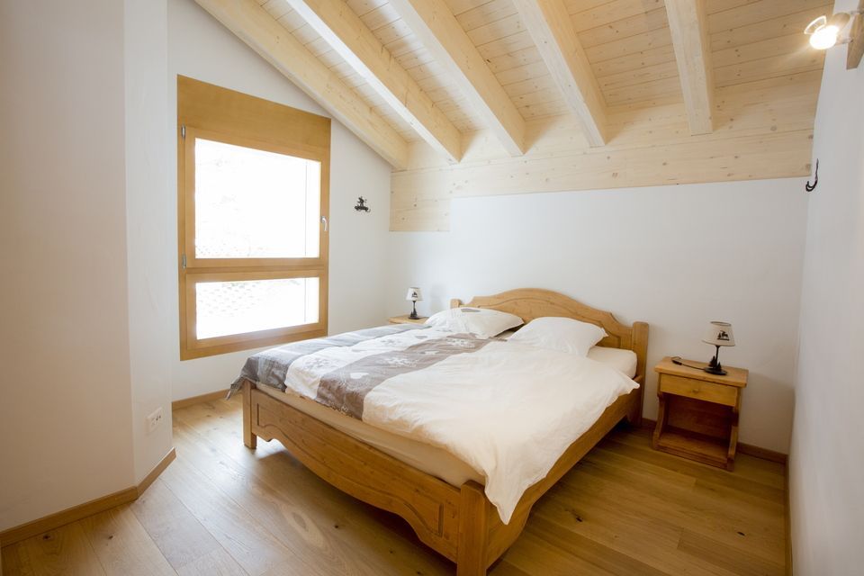 Une chambre avec un lit en bois et un plafond en bois