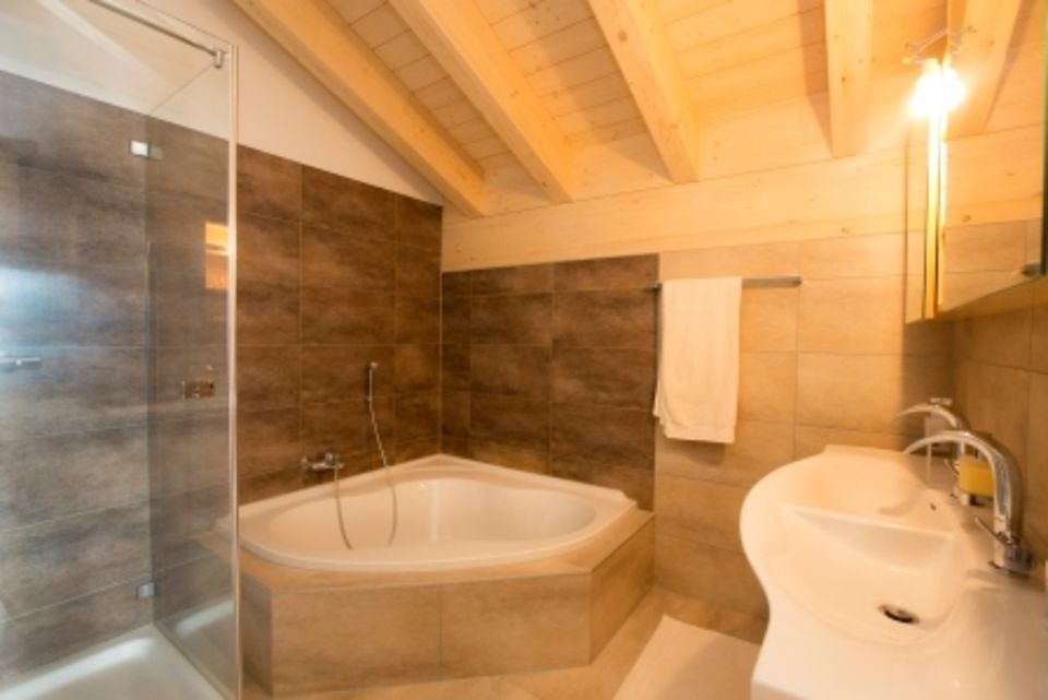 Une salle de bain avec baignoire, lavabo et douche.