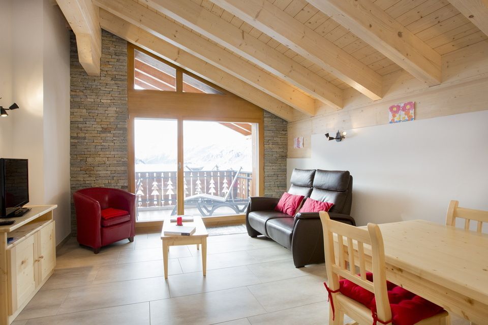 Un salon avec un canapé, une chaise, une table et une télévision