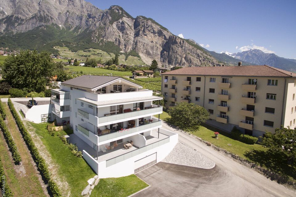 Une vue aérienne d'un bâtiment avec des montagnes en arrière-plan