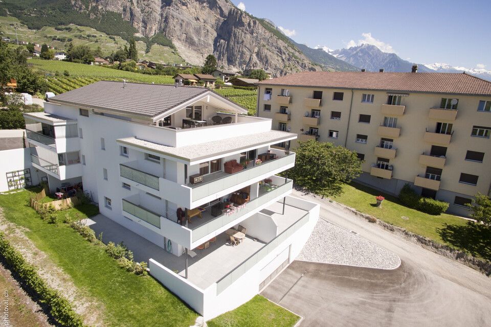 Une vue aérienne d'un bâtiment avec des montagnes en arrière-plan
