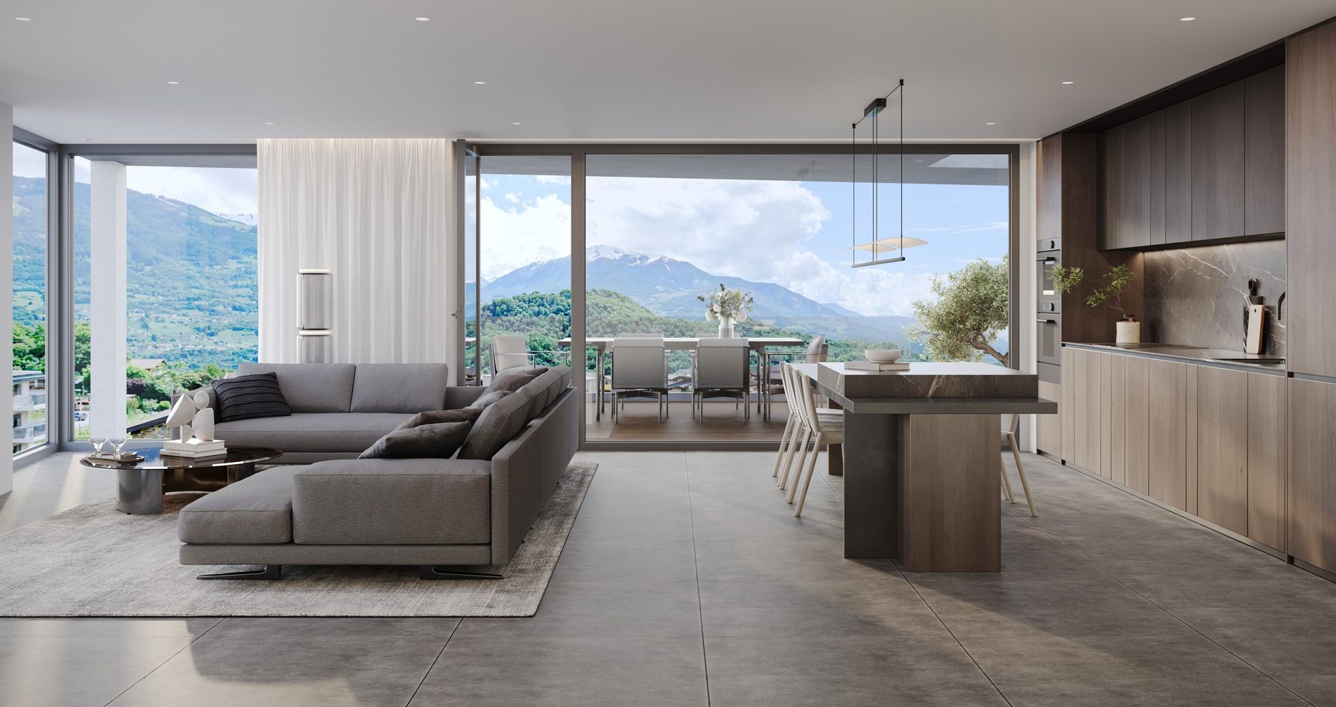 Salon moderne avec vue sur la montagne, canapé gris, cuisine ouverte et coin repas.