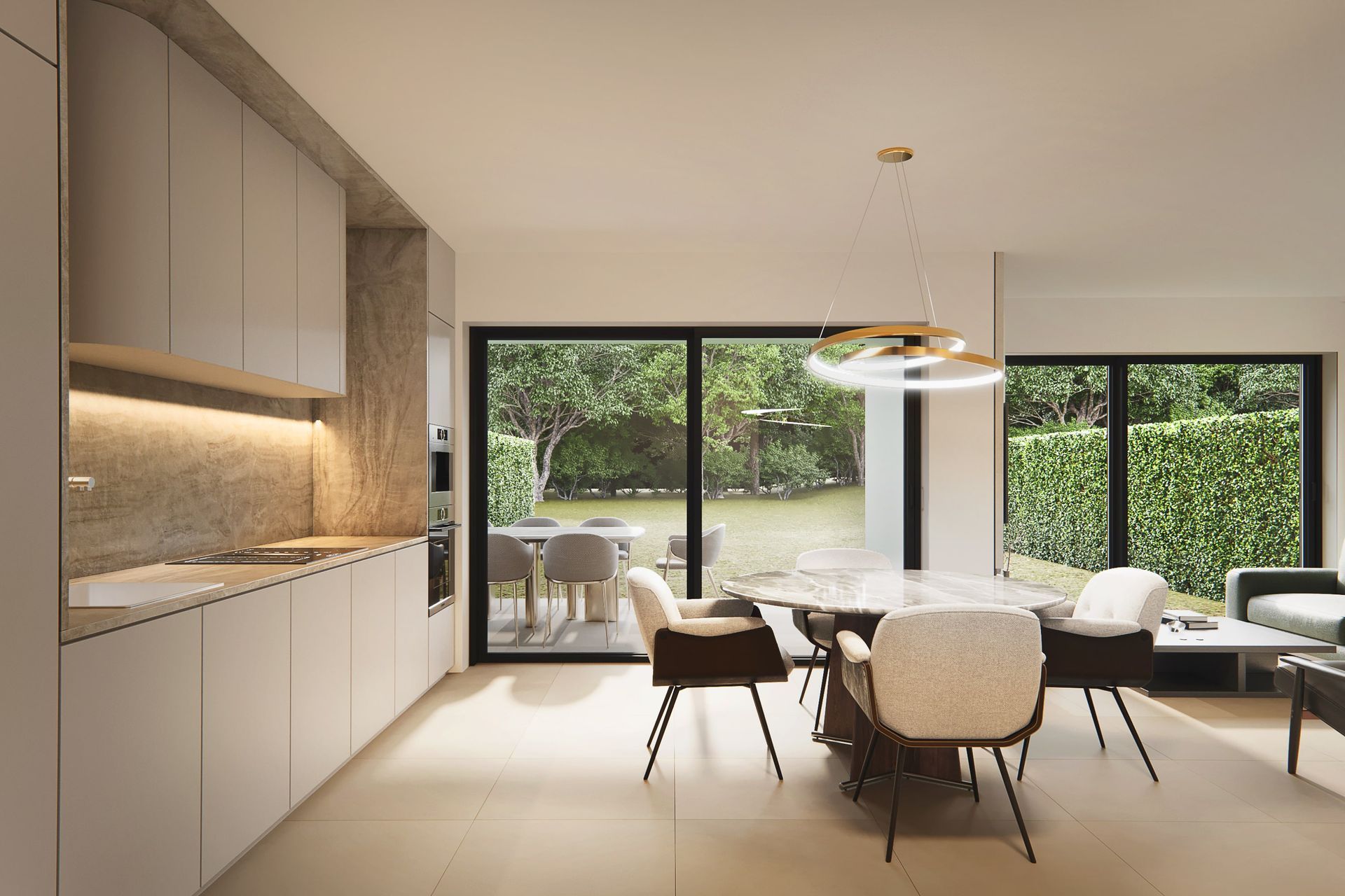 Cuisine-salle à manger moderne avec placards clairs, table en marbre et vue sur un jardin luxuriant.