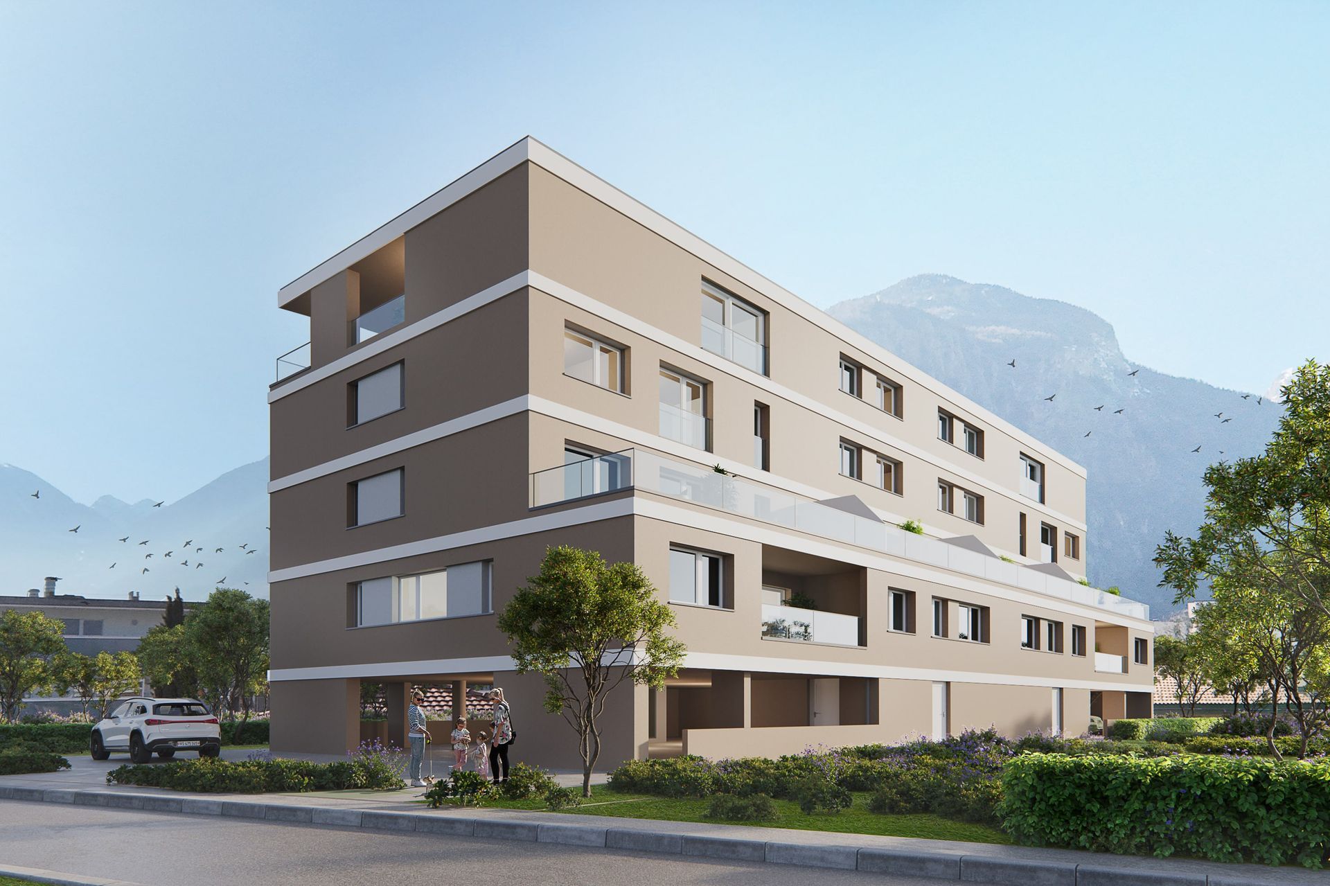 Immeuble d'appartements moderne beige avec balcons, montagnes en arrière-plan.