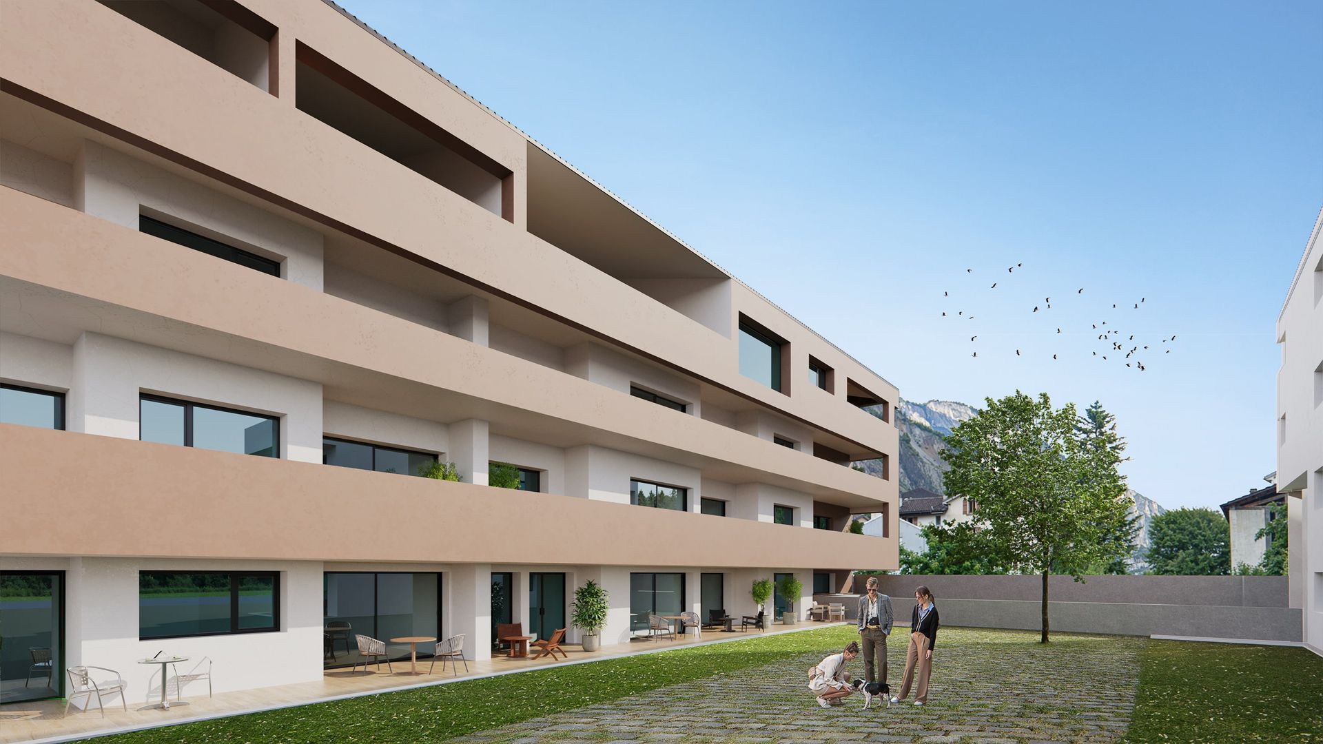 Extérieur d'un immeuble d'appartements moderne avec pelouse, passants et montagnes en arrière-plan.