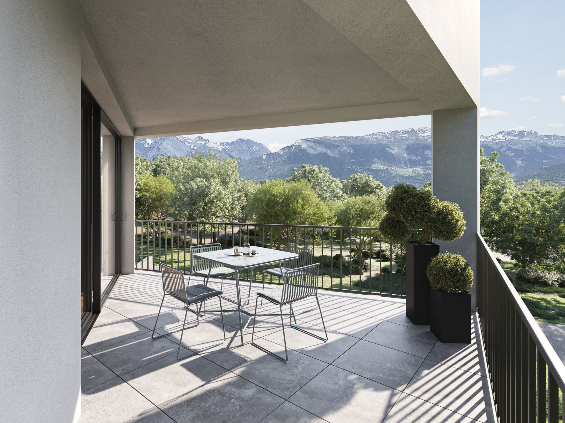 Balcon avec table et chaises donnant sur les montagnes et les arbres. Journée ensoleillée.