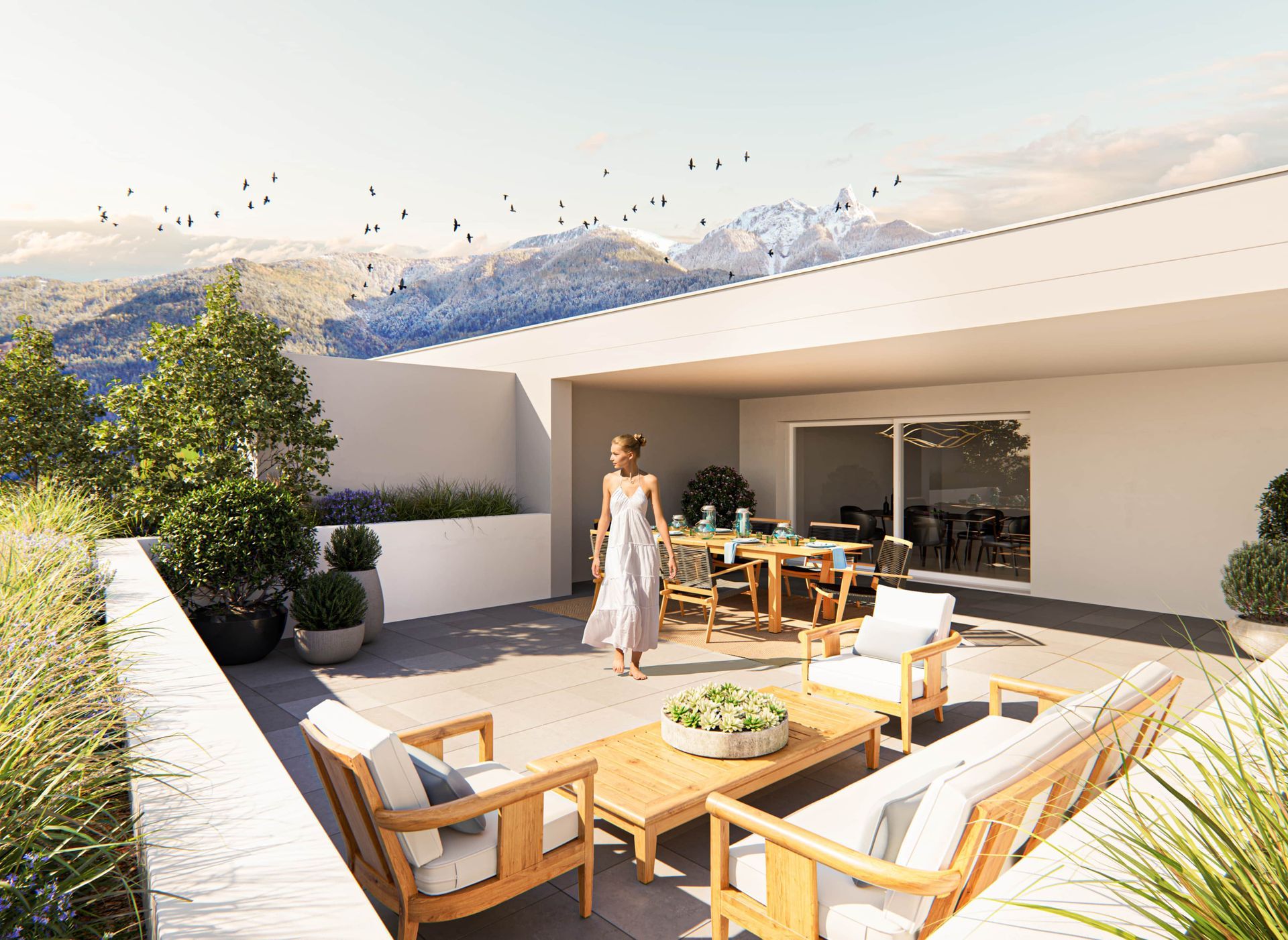 Terrasse avec vue sur la montagne, femme qui marche. Table à manger extérieure, coin salon, arbres, ciel bleu.