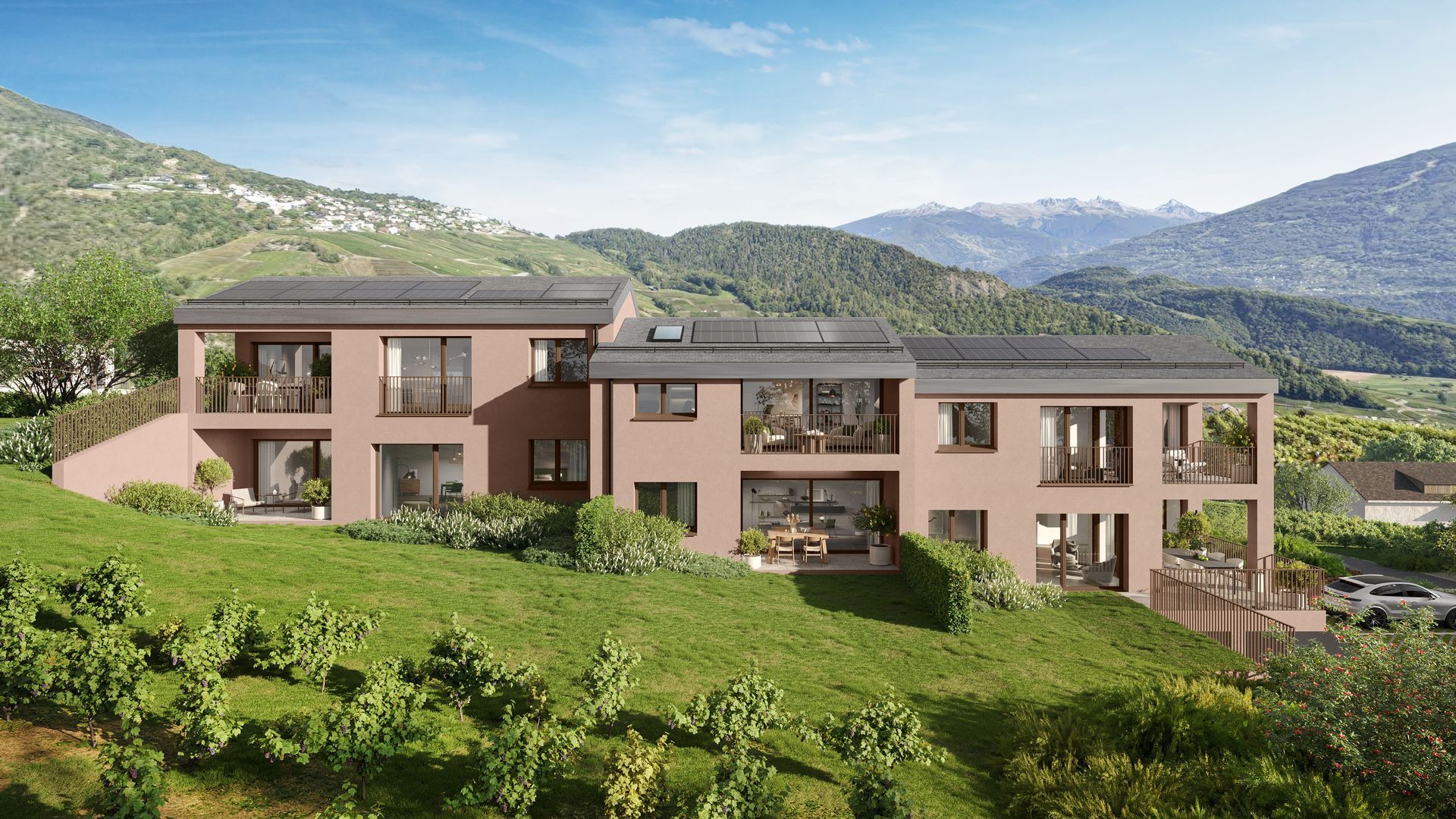 Immeuble d'habitation moderne à plusieurs logements, situé à flanc de colline et entouré de verdure et de montagnes.