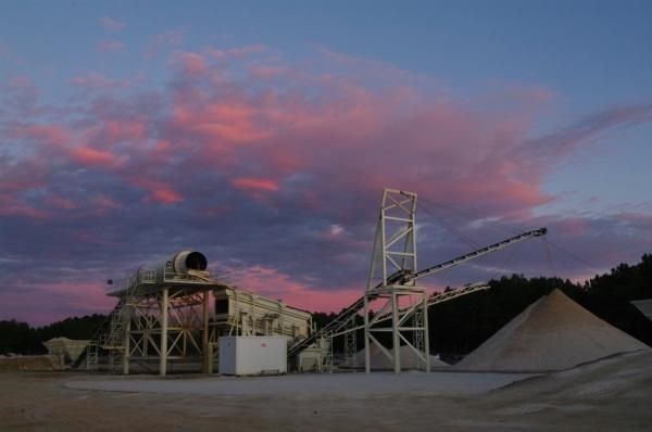 Una obra en construcción con una puesta de sol al fondo.