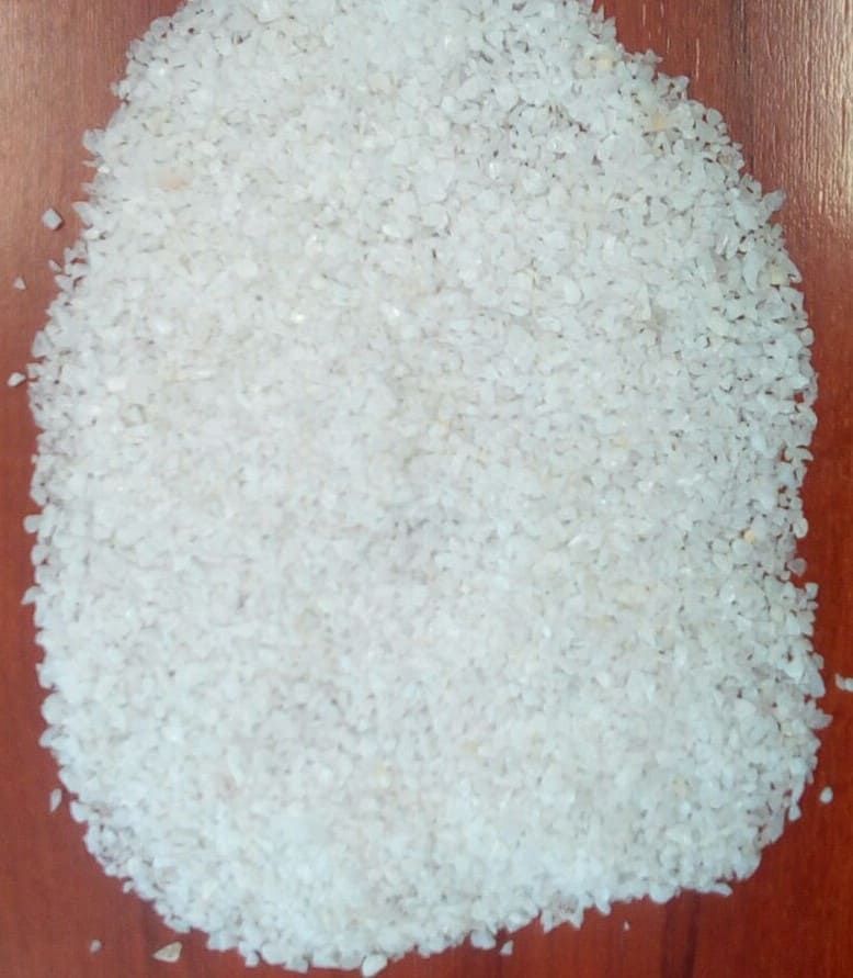 Una pila de arroz blanco está sobre una mesa de madera.