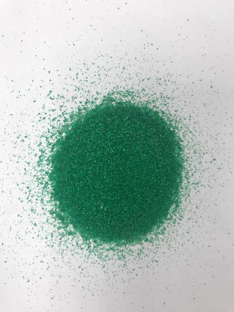 Una pila de brillantina verde reposa sobre una superficie blanca.