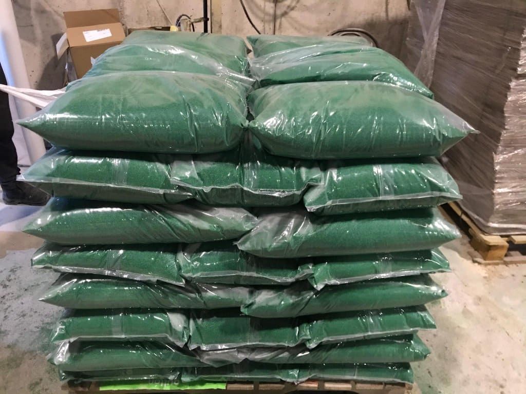 Una pila de bolsas verdes apiladas una encima de otra sobre un palé.