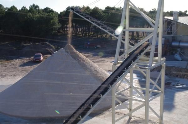 Una cinta transportadora pasa sobre una pila de arena