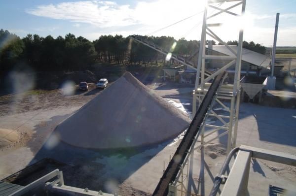 Una cinta transportadora lleva una pila de arena