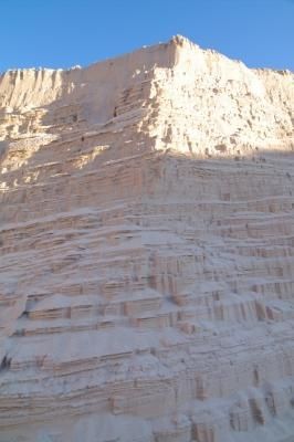 Una gran colina de arena con un cielo azul al fondo