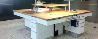 Hölzerne Laborwerkbank mit montiertem Gerät in einem gefliesten Werkstattraum