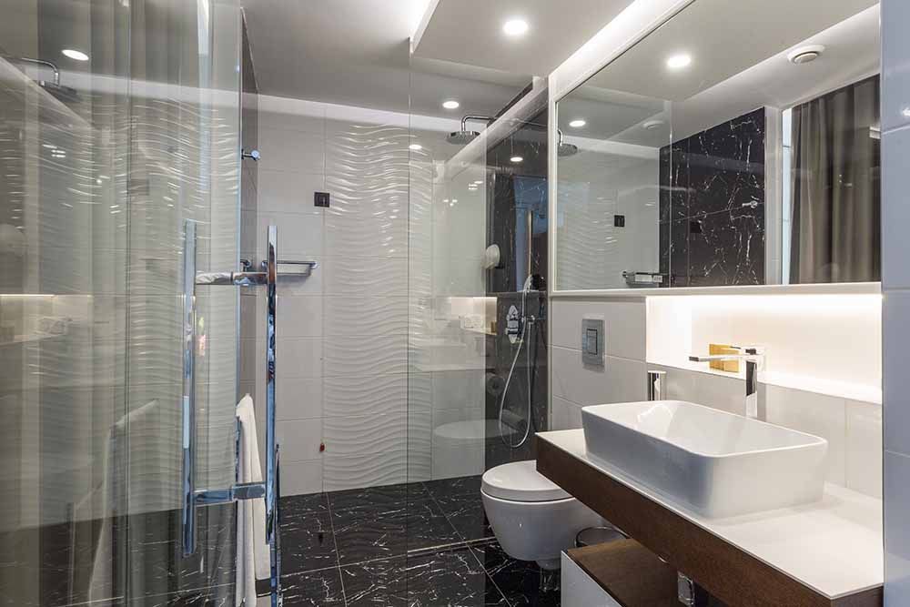 Ein Badezimmer mit Waschbecken, Toilette, Dusche und Spiegel.