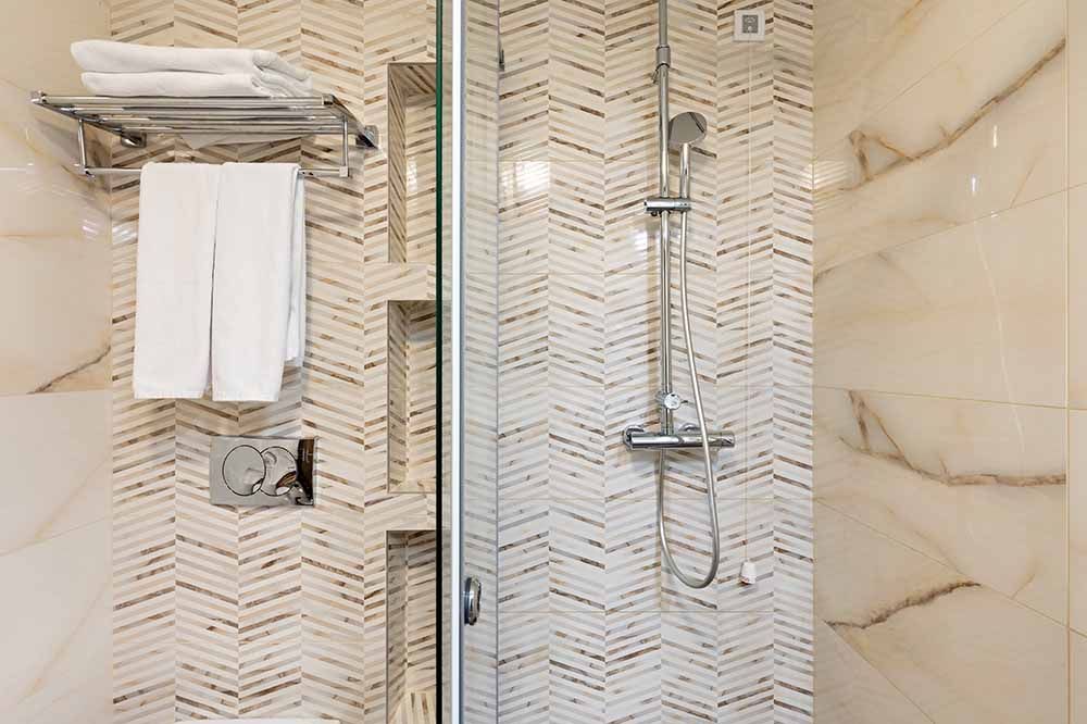 Ein Badezimmer mit Dusche, Toilette und Handtuchhalter.