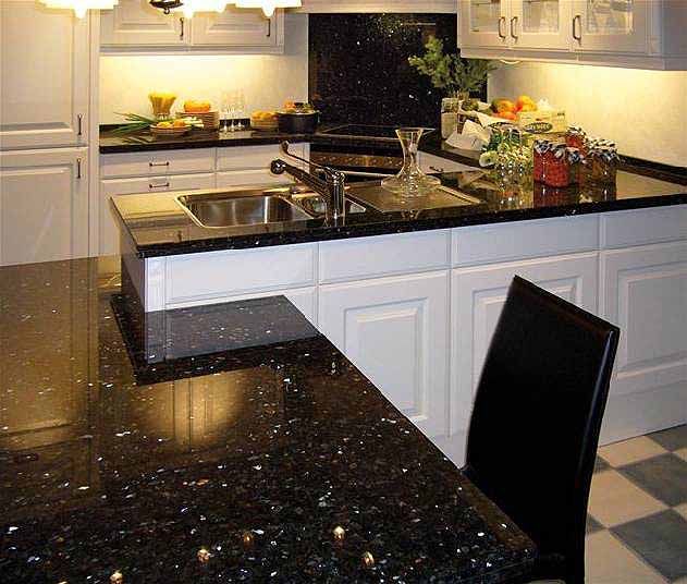 Eine Küche mit schwarzen Granitarbeitsplatten und weißen Schränken
