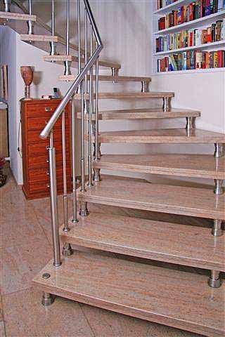 Eine Treppe mit Granitstufen und einer Kommode im Hintergrund.