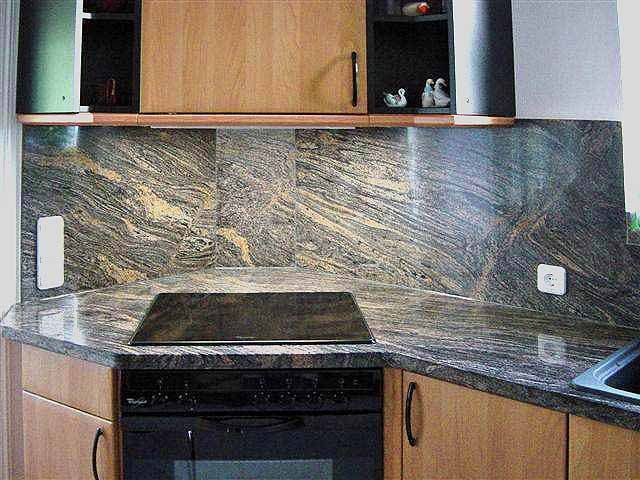 Eine Küche mit Natursteinarbeitsplatten und Holzschränken