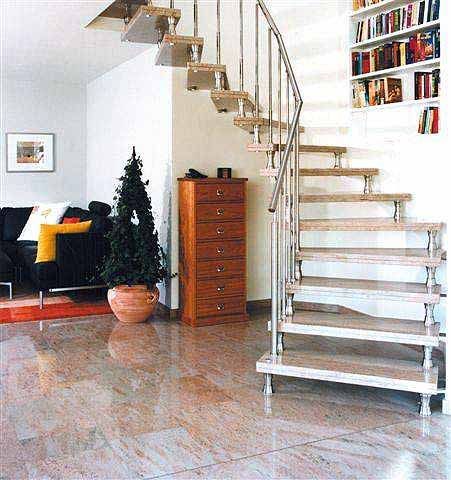 Ein Wohnzimmer mit einer Natursteintreppe, die in die zweite Etage führt