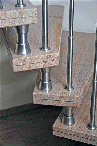 Eine Nahaufnahme einer Wendeltreppe aus Granit und Edelstahl.