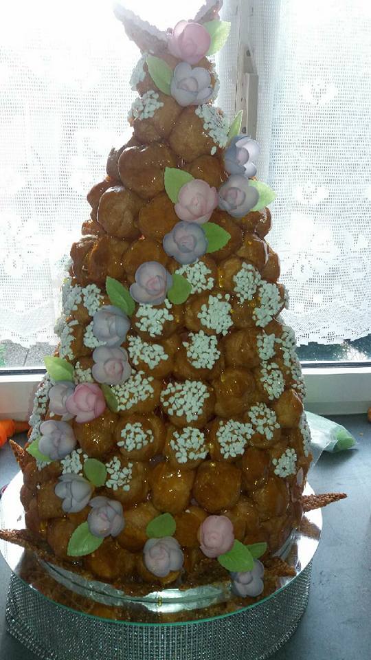 Tour de pâte croquembouche décorée de fleurs en sucre et de vermicelles.