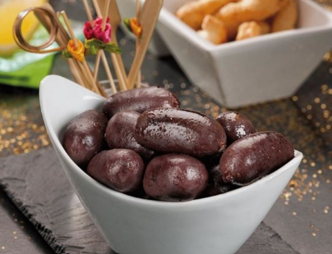 Bol de morcilla brun foncé (boudin noir) sur une surface sombre.