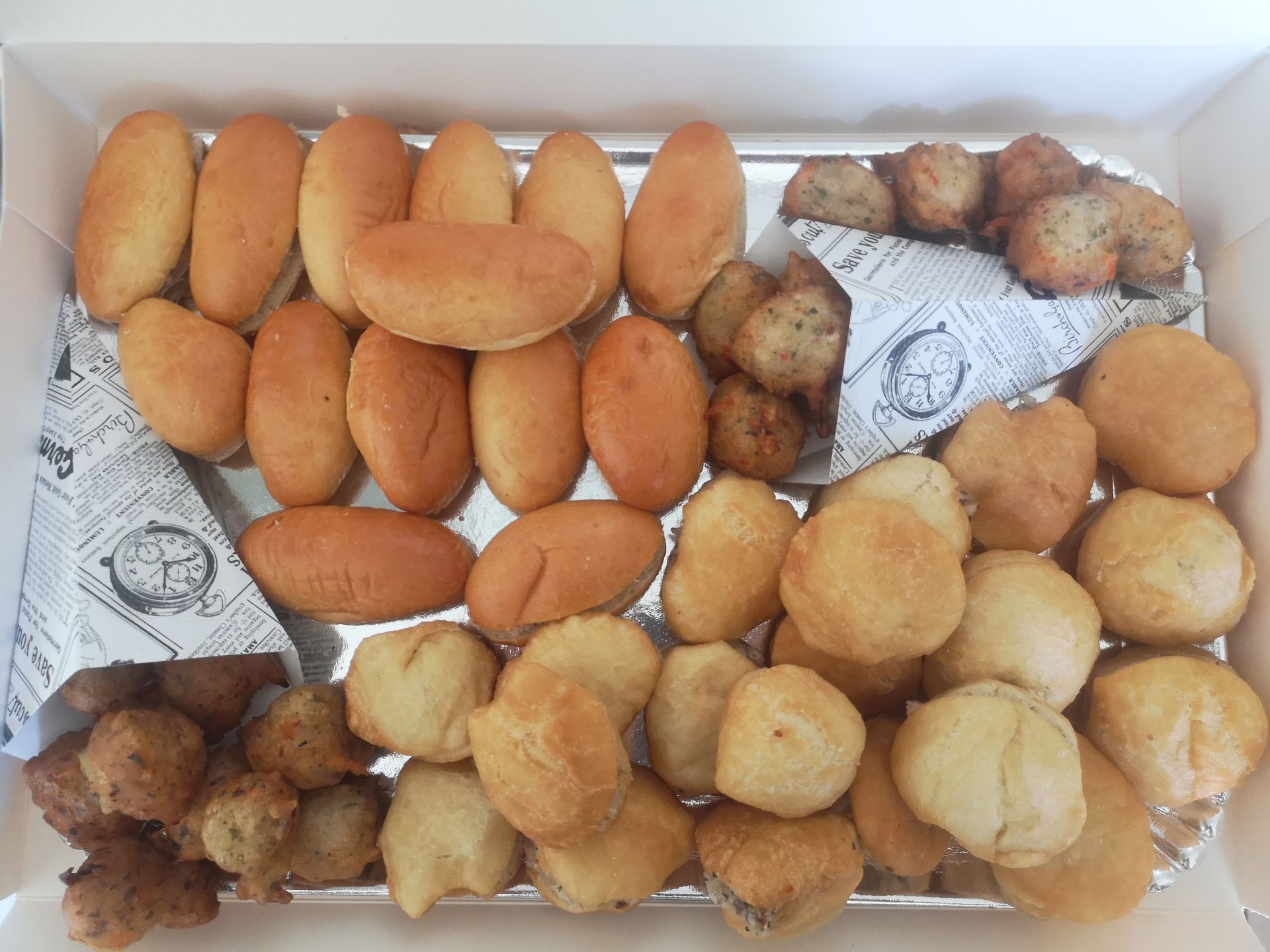 Plateau d'aliments frits assortis comprenant des petits pains et des boulettes.